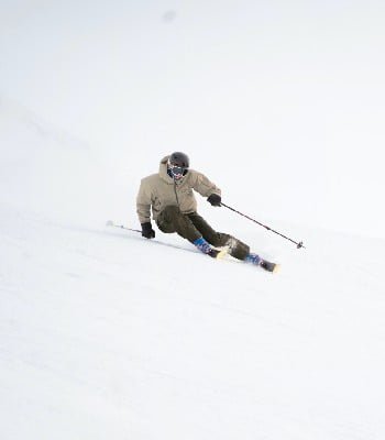 Skier carving on a steep hill